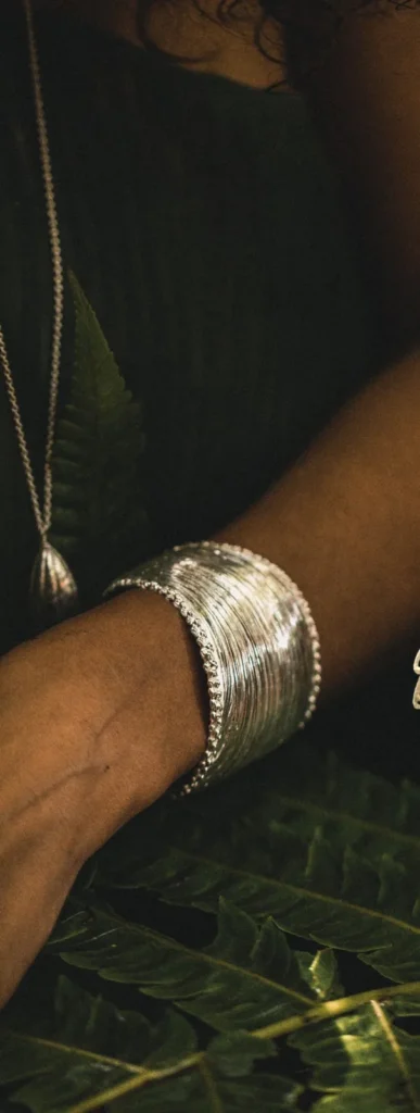 Palm cuff, a gold cuff bracelet shaped like a palm frond, worn
